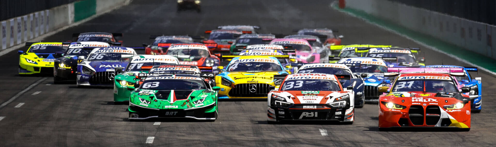 Startphase eines DTM-Rennens mit mehreren Tourenwagen auf der Rennstrecke am DEKRA Lausitzring