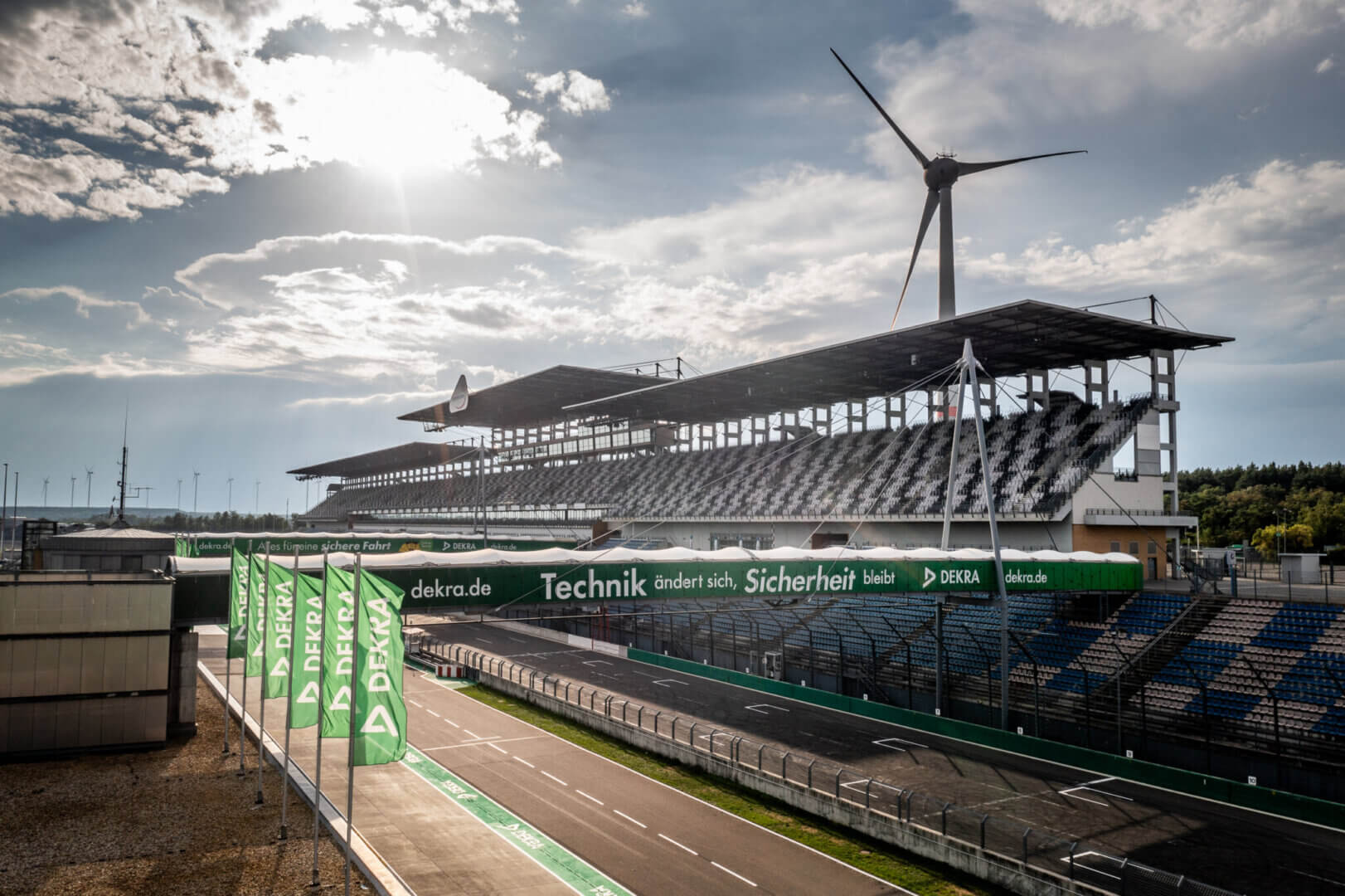 Titelbild des DEKRA Lausitzring Webshops mit Blick auf die Start-Ziel-Gerade und Haupttribüne, Symbol für Fahrerlebnisse, Trainings und Gutscheine