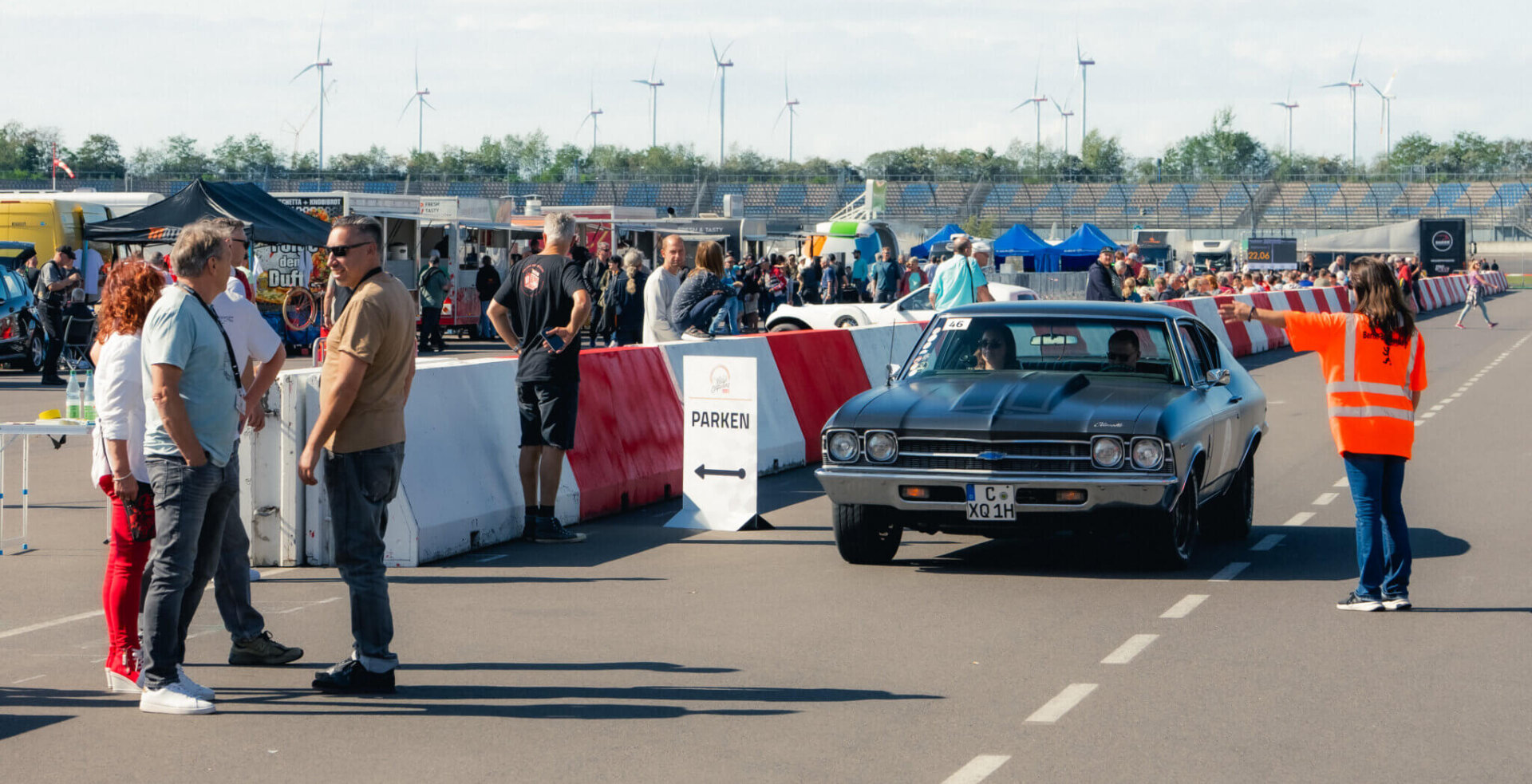 Klassischer US-Oldtimer fährt bei den DEKRA Klassik Tagen durch den abgesperrten Veranstaltungsbereich mit Zuschauern