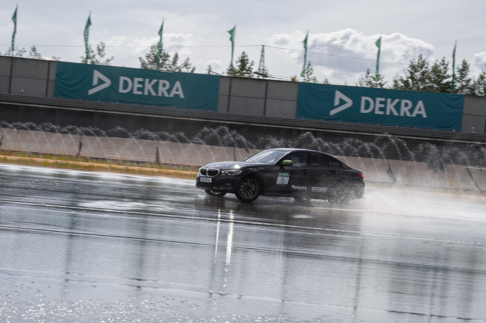 Schwarzer BMW beim PKW Perfektions-Training am DEKRA Lausitzring, präzises Fahrverhalten und Fahrzeugkontrolle auf nasser Strecke für erfahrene Fahrer