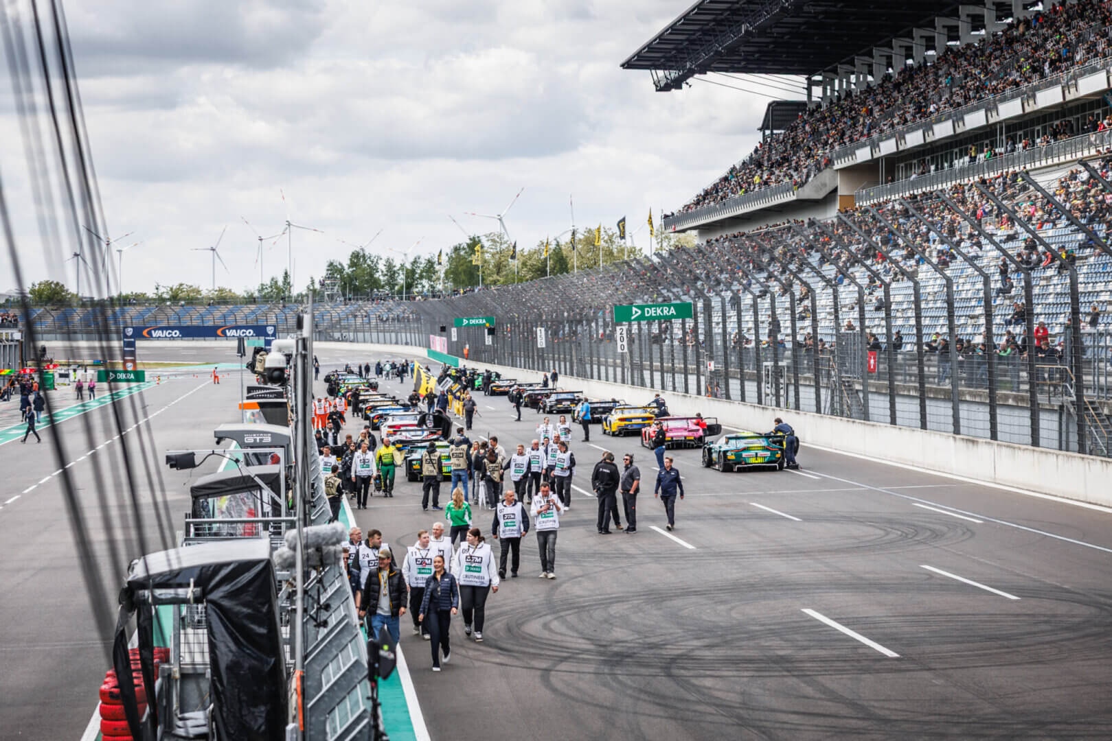 Startaufstellung der DTM mit Rennfahrzeugen, Teams und Zuschauern auf dem DEKRA Lausitzring