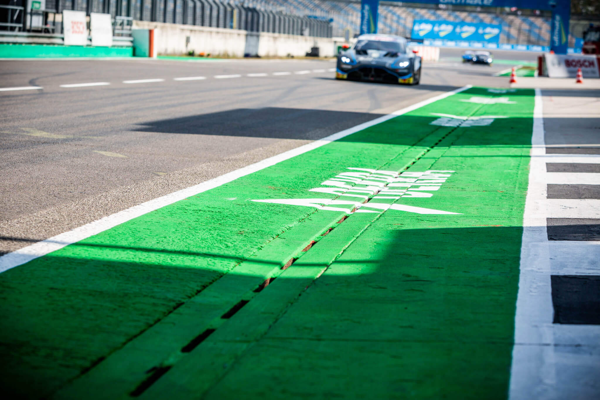 Nahaufnahme des DEKRA-Schriftzugs in der Boxengasse der Grand-Prix-Strecke des DEKRA Lausitzrings